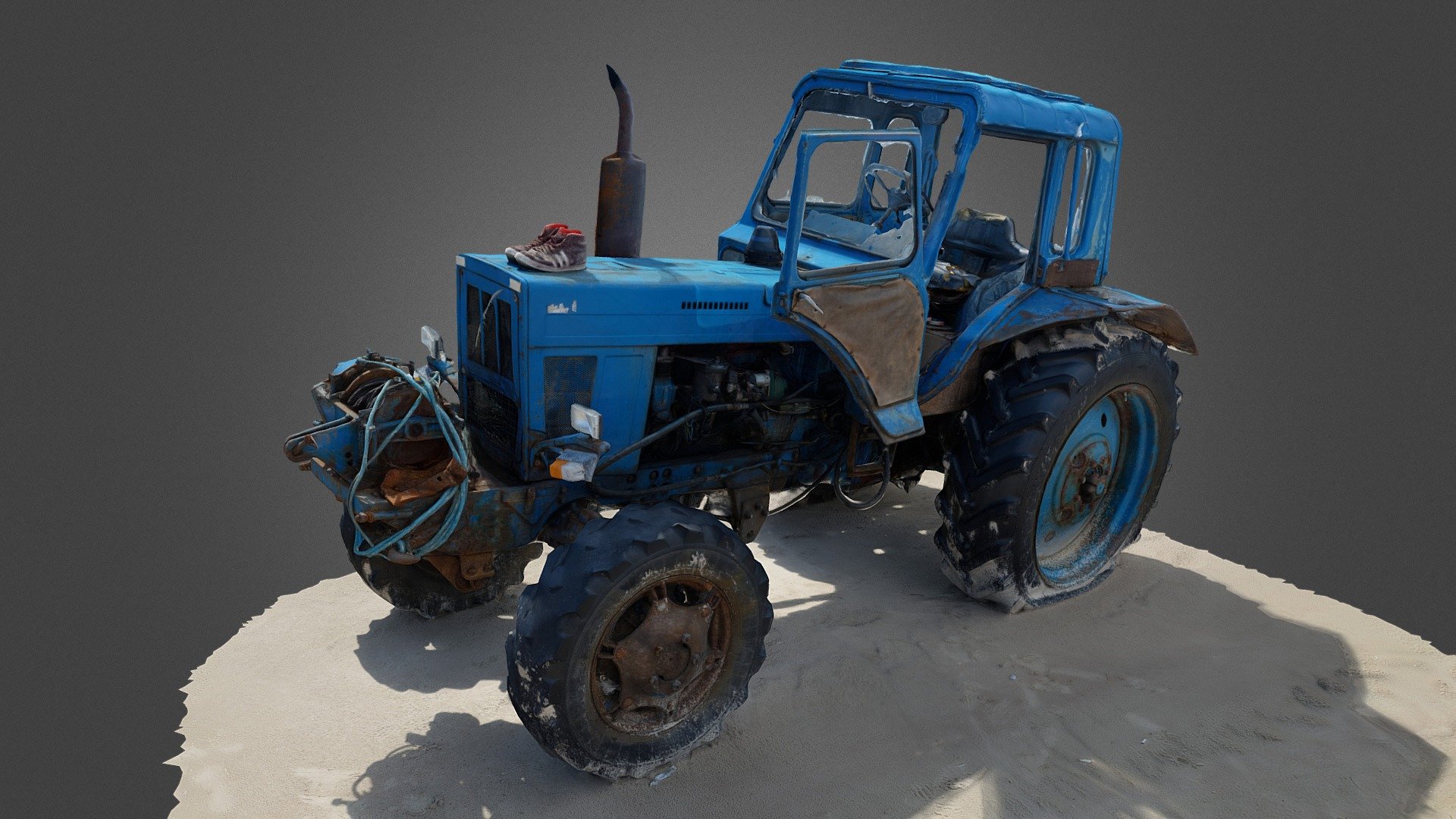 Old, rusty, blue tractor seemingly abandoned at a sea shore. 
Rusty metal, one flat tire, sand on tires, broken glass. 
A pair of sneakers on the front for some reason 3d model