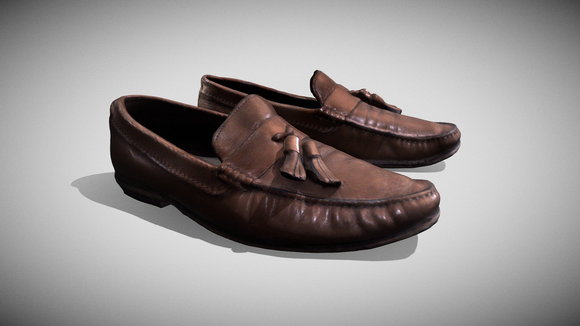 A pair of tatty old brown leather loafers. Worn for many a year. They are comfortable slip on shoes and have tassles on top for decoration 3d model