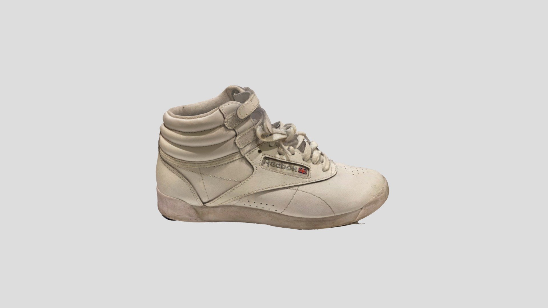 A woman's hi-top Reebok trainer. White with a little bit of dirt. Laces and velcro straps. Very stylish, for use in a girl or woman's bedroom, gym or sports scene 3d model